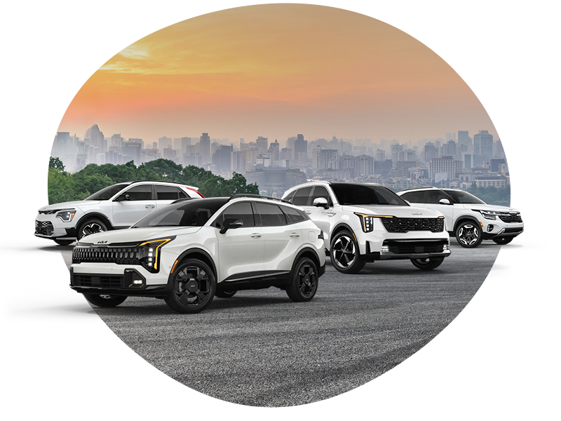 Four white Kia SUVs parked on pavement with a city skyline and orange sunset in the background.