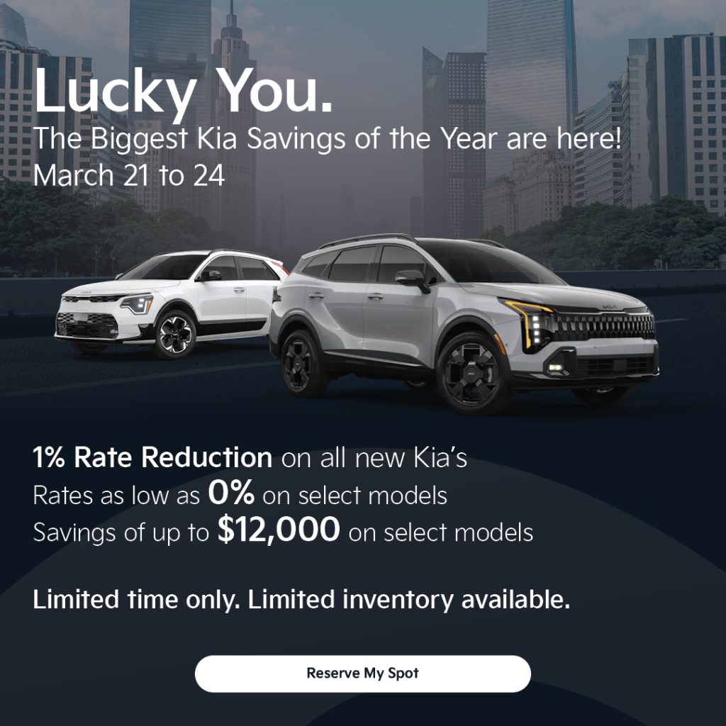 Kia sales promotion featuring two Kia SUVs in front of a city skyline with headline “Lucky You – The Biggest Kia Savings of the Year are here! March 21 to 24.” Offer includes a 1% rate reduction, rates as low as 0%, and savings up to $12,000 on select models with “Reserve My Spot” call to action.